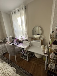 a small bedroom with a desk and a mirror